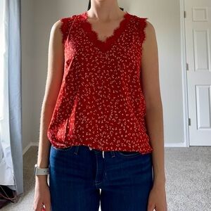 Red/rust colored cap sleeve shirt with lace detailing around neckline